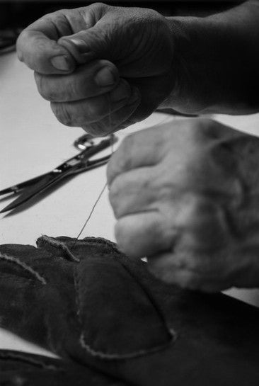 artisan sewing handmade gloves